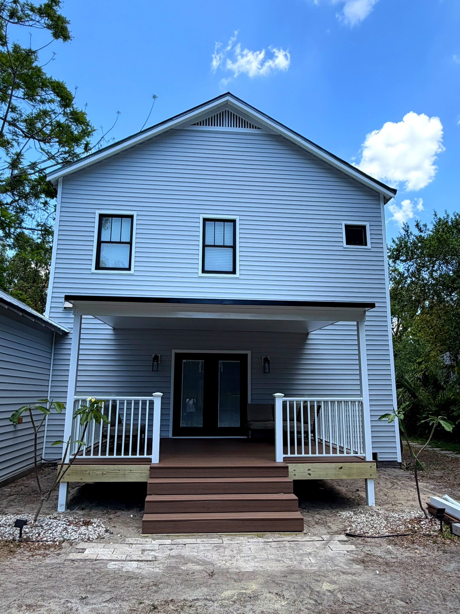 Finished vinyl siding installation on a two-story home with covered porch in Land O Lakes, Florida