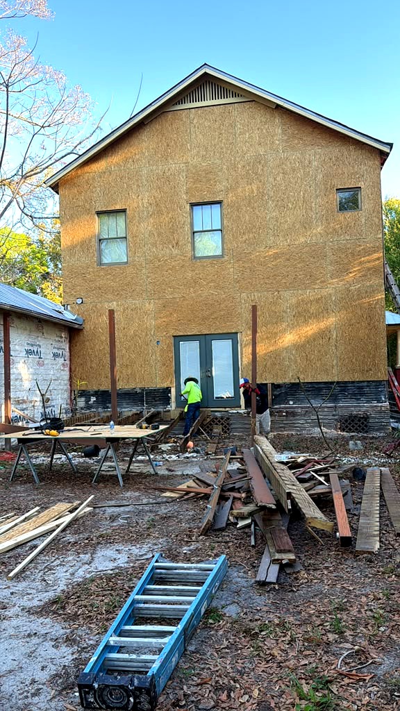 OSB sheathing installed on a two-story home with crew working on site in Land O Lakes, Florida