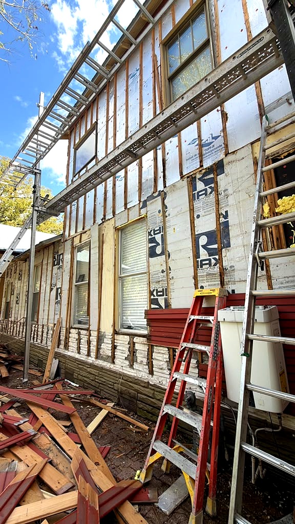 Old siding removed down to house wrap and insulation board during a Tampa Bay siding project